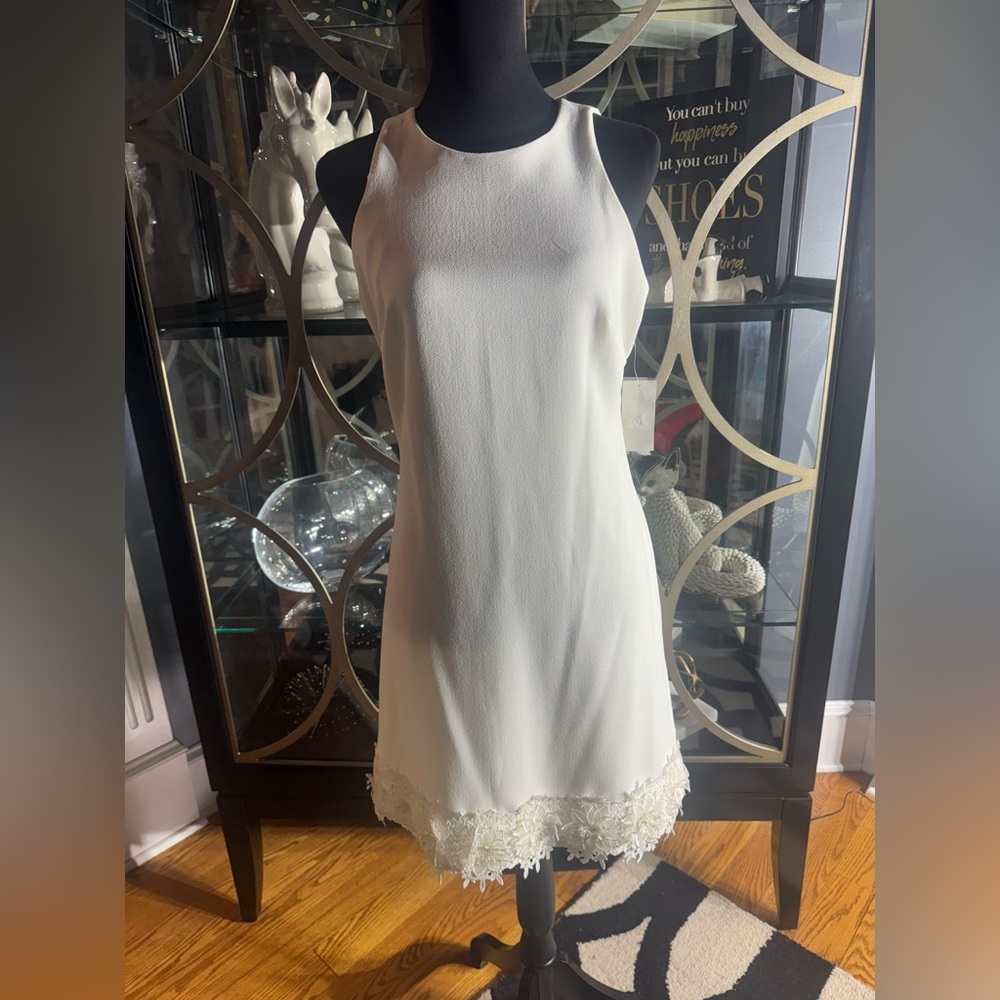 Chic White Sleeveless Dress with Floral Appliqué Hem